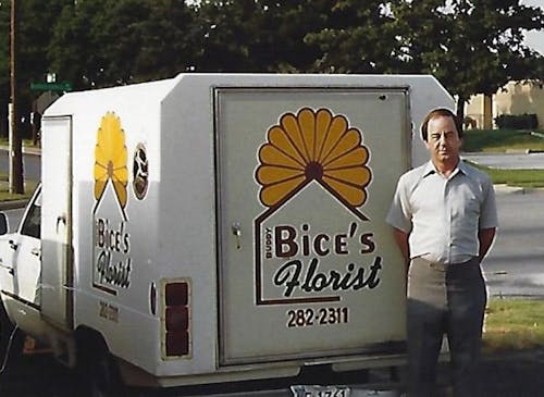 Buddy Bice, our beloved founder, posing alongside one of his earliest delivery trucks